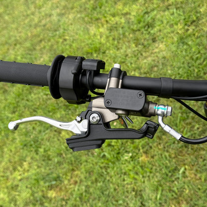 Close-up of motorcycle handlebar with brake lever on a grass background